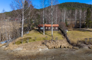 HØY AVGIFT: Denne hytta, like ved kommunehuset ved Krøderfjorden, har nesten dobbelt så høy fastavgift for vann og mer enn dobbelt så høy fastavgift for avløp, som kommuehuset i Krødsherad. Foto: Lars Eivind Bones / Dagbladet